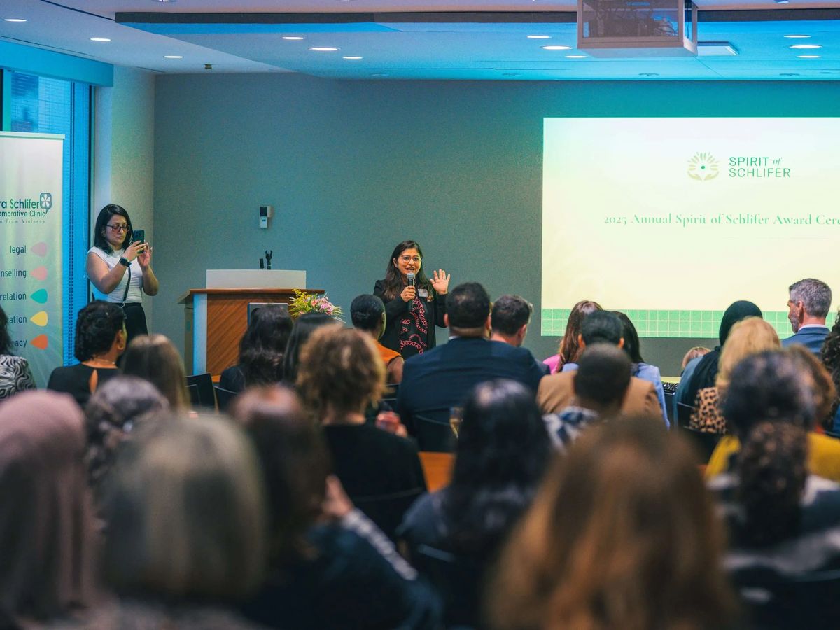 A speaker captivates the audience at the SHE MATTERS Fundraiser, with the event logo on display.