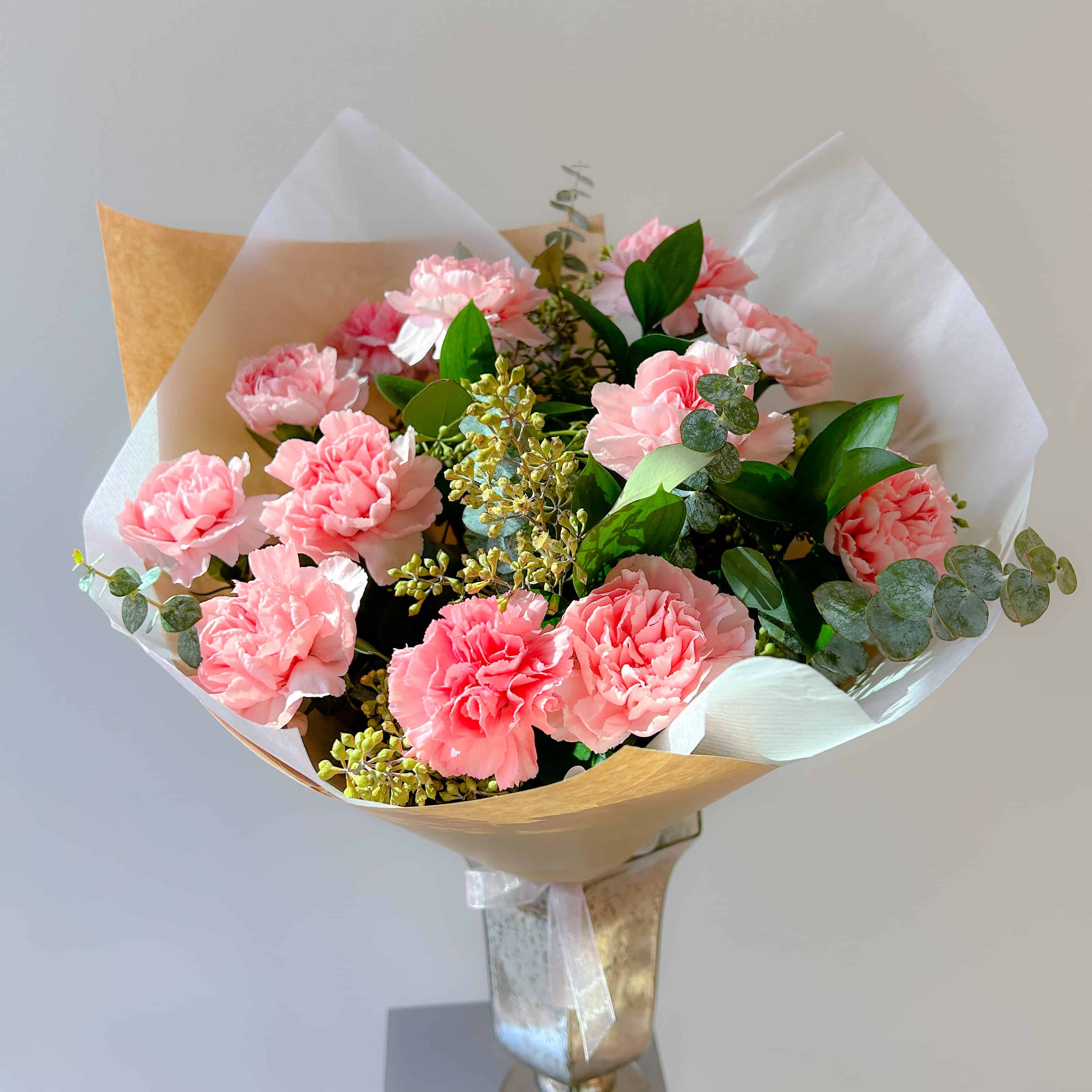 Pink carnations and seeded eucalyptus flower bouquet