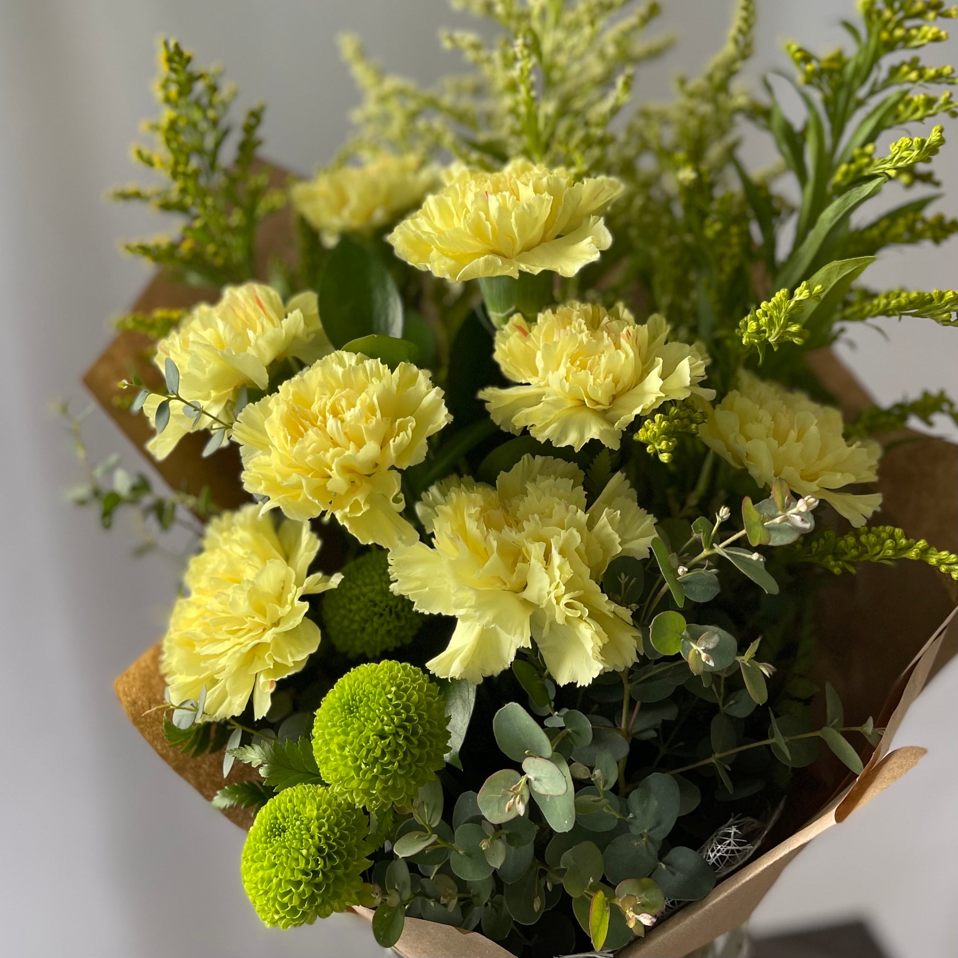 Yellow bouquet of carnations, eucalyptus, and chrysanthemums