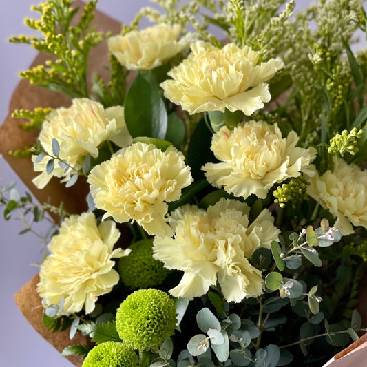 The full-bodied, radiant glow of yellow carnations and chrysanthemums to warm the heart